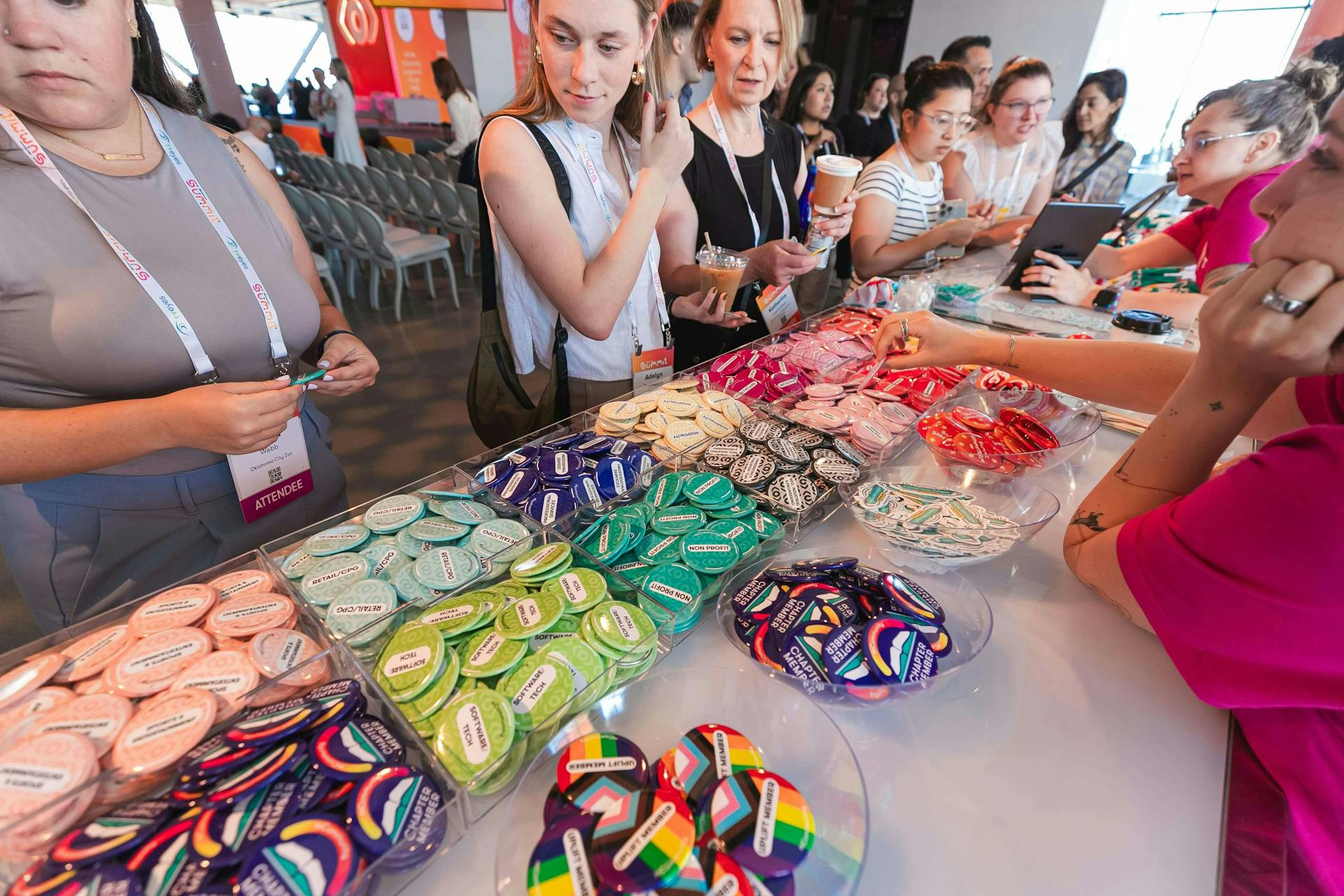 image attendees looking at the colorful badges available at the mCommunity Lounge during Meltwater Summit 2024