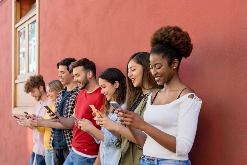 jeunes gens souriant et naviguant sur leur téléphone