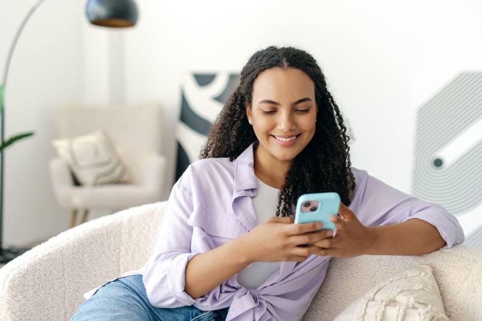 Une jeune fille qui consulte des contenus de médias sociaux sur son téléphone 