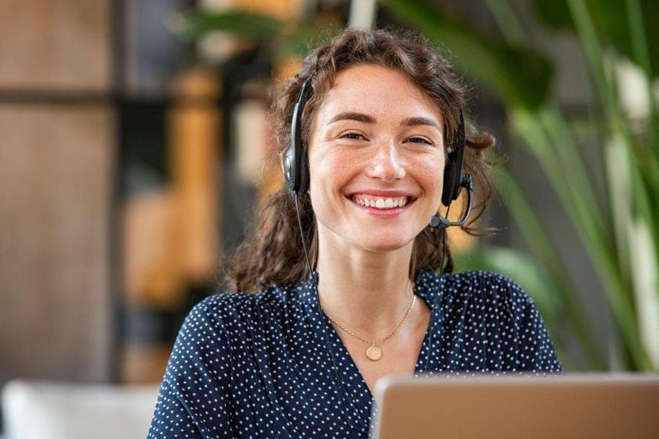 young woman smiling and working on a laptop