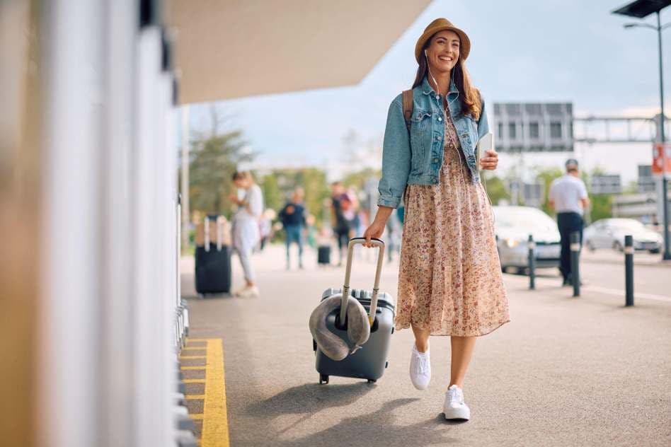 female travel influencer with her luggage at the airport